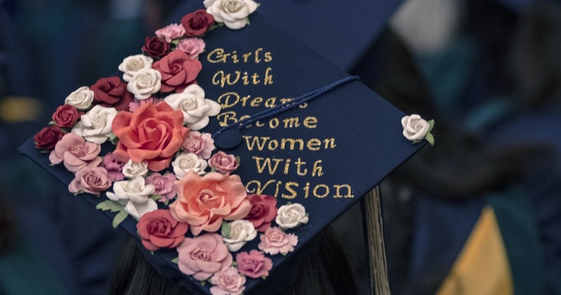 Graduation cap decorated with flowers and writing that reads: "Girls with dreams become women with vision"
