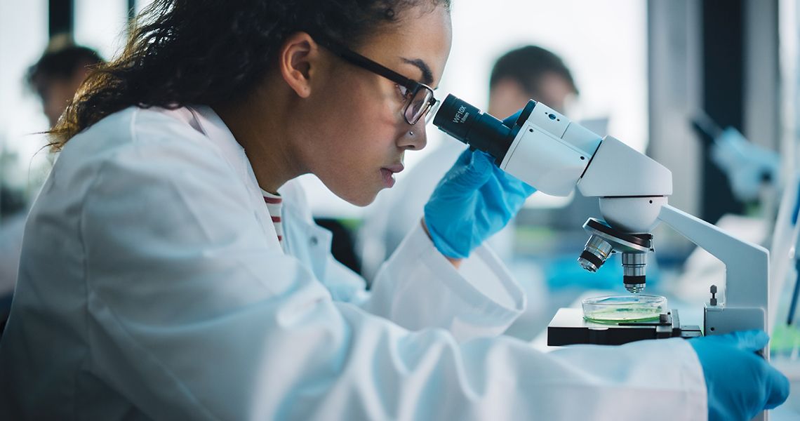 medical science laboratory scientist looking under microscope
